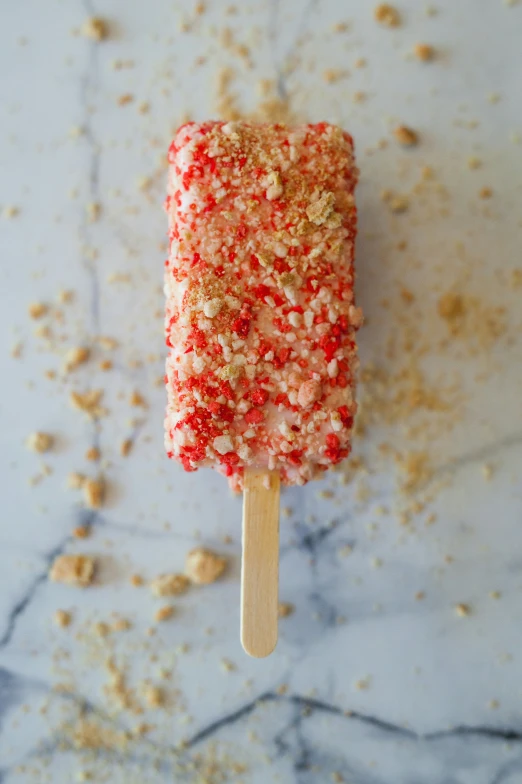 a red and white frosted popsicle sitting on a table