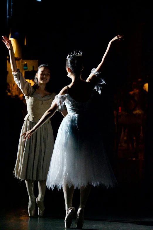 ballerinas in tutus pose while looking at the ground