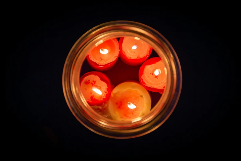 a jar with a few candles inside of it