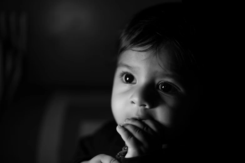 a baby is in a chair with its hand on his chin