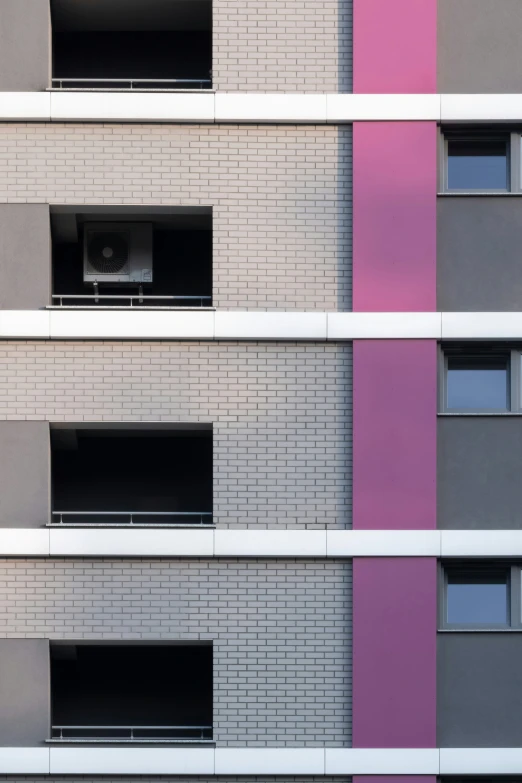 an angled view of a building with windows and a building with two cars