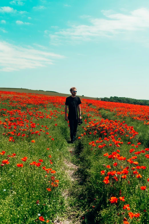 a man is walking through a flowery field