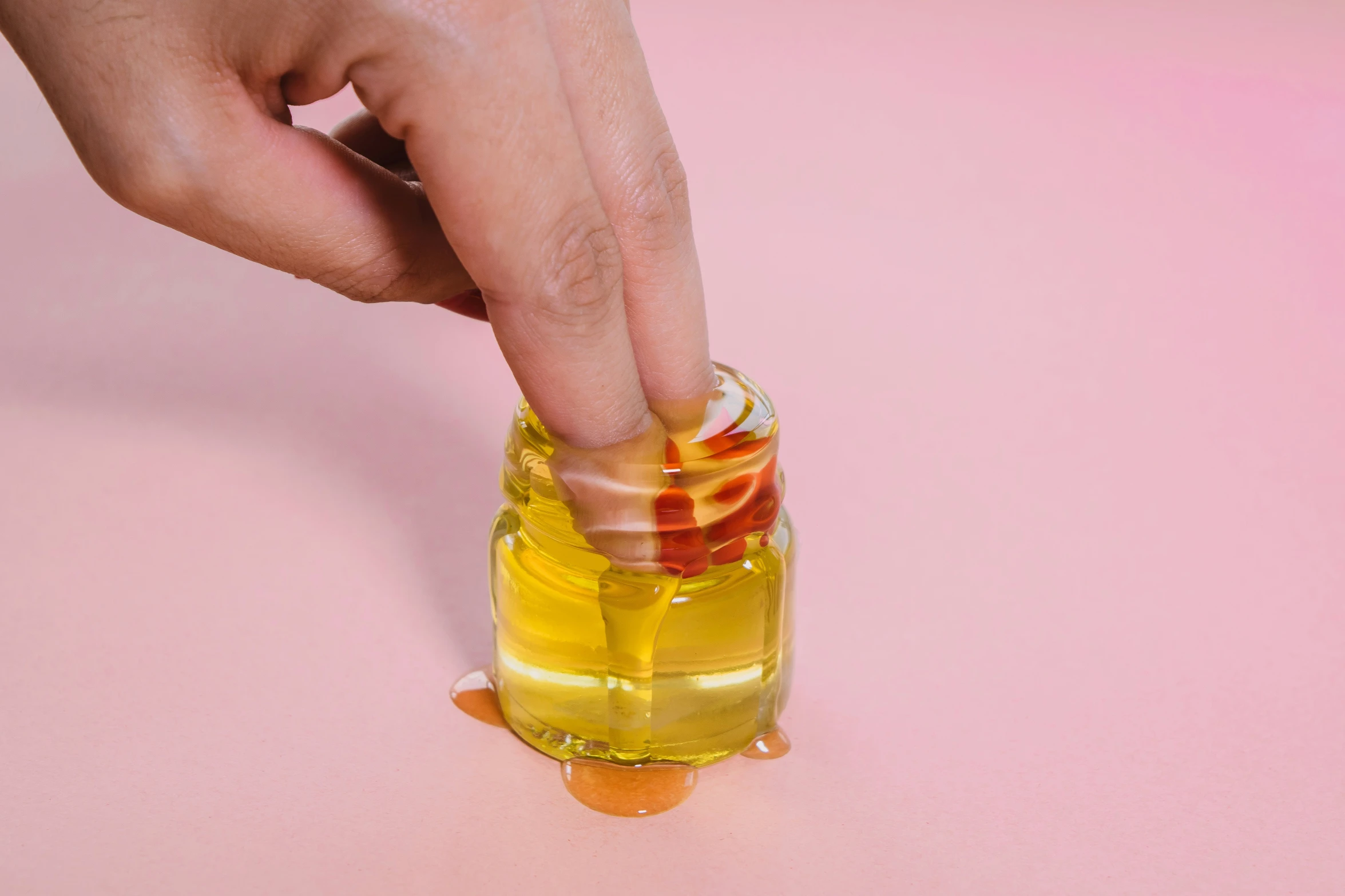 a person pouring liquid into a glass bottle