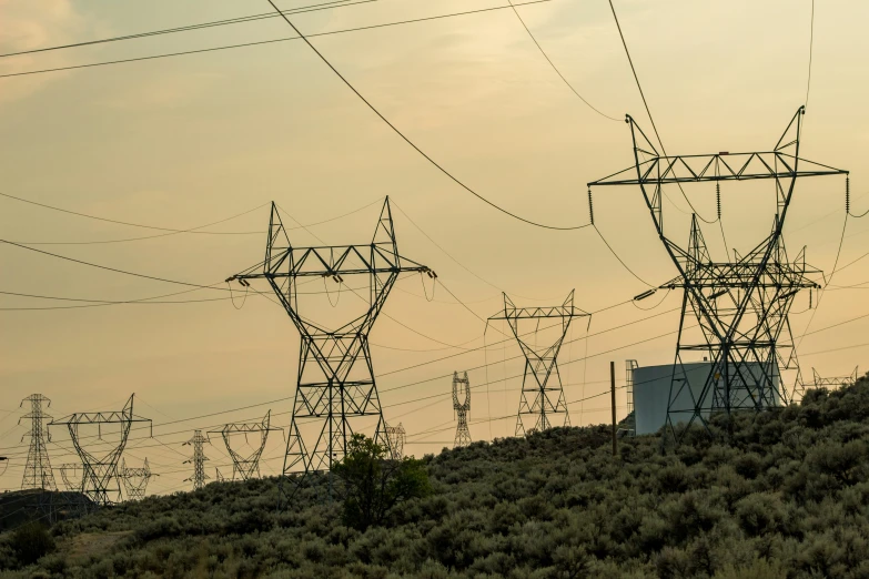 a very tall tower and power lines in a valley