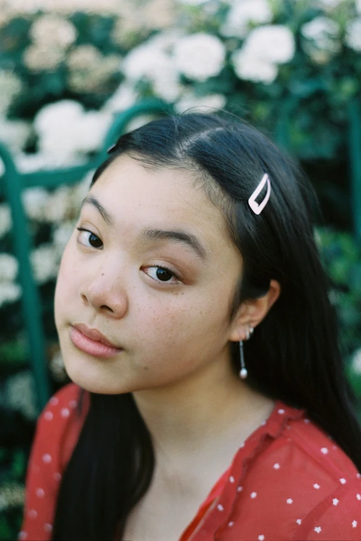 a girl in red shirt next to shrubbery