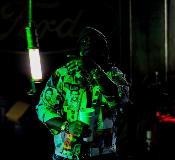 a man with green light up clothes holding a microphone