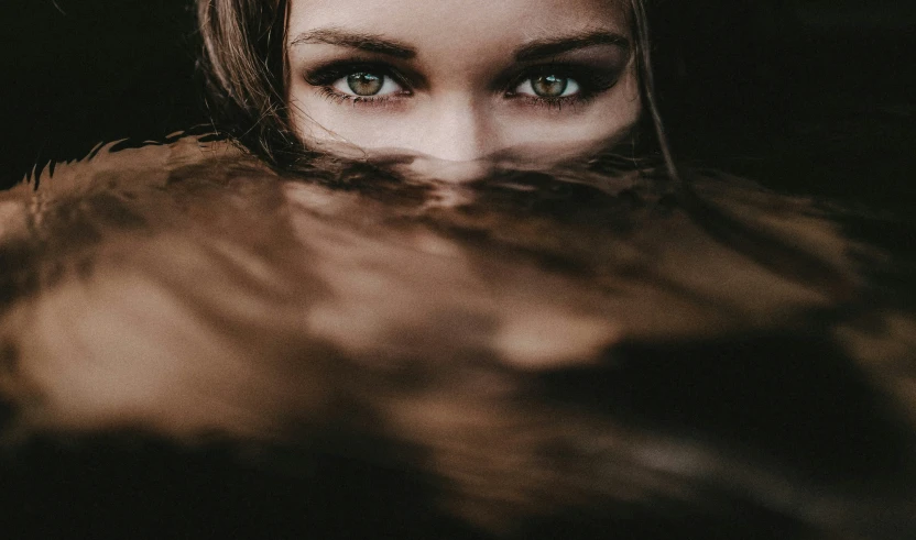 a girl's eyes are reflecting her face and hair