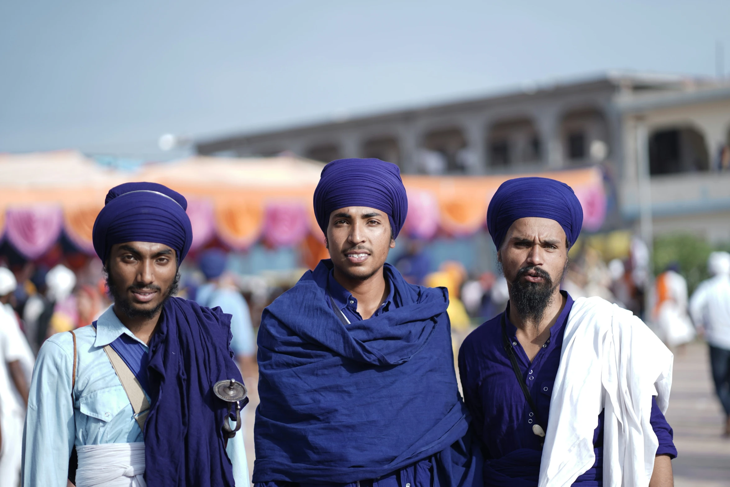 three indian men in purple turbans on a street