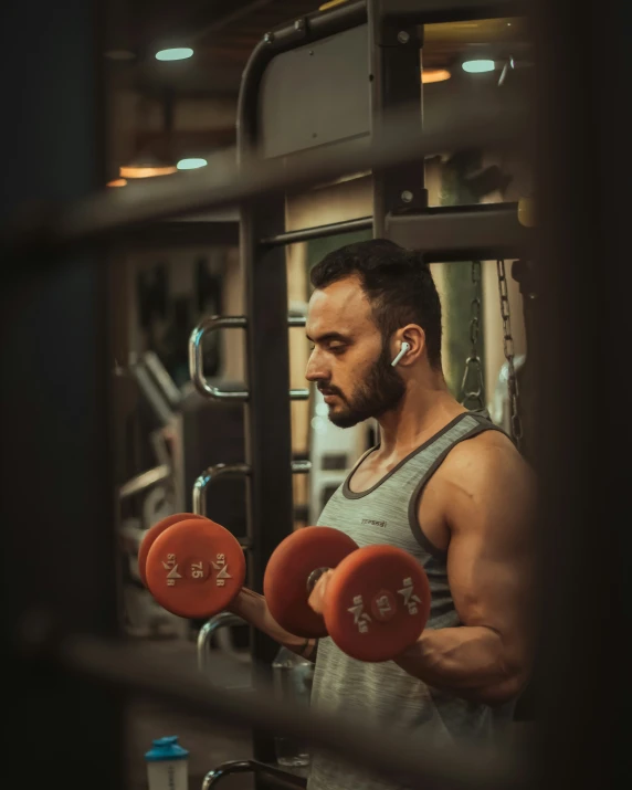 a man working out with red dumbbells in a gym