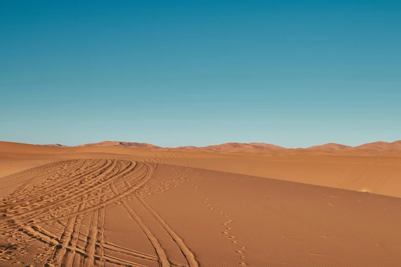 the tire tracks in the sand are visible