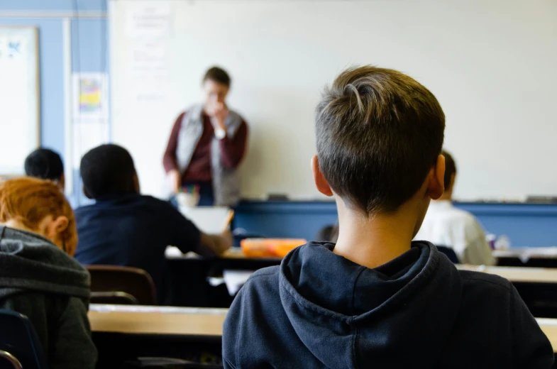 a group of people that are in front of some desks