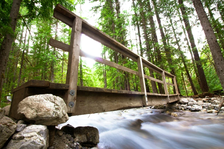 a small wooden bridge that is going over a river