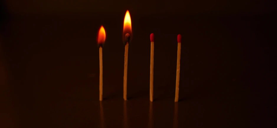 the candles are burning brightly on a dark surface