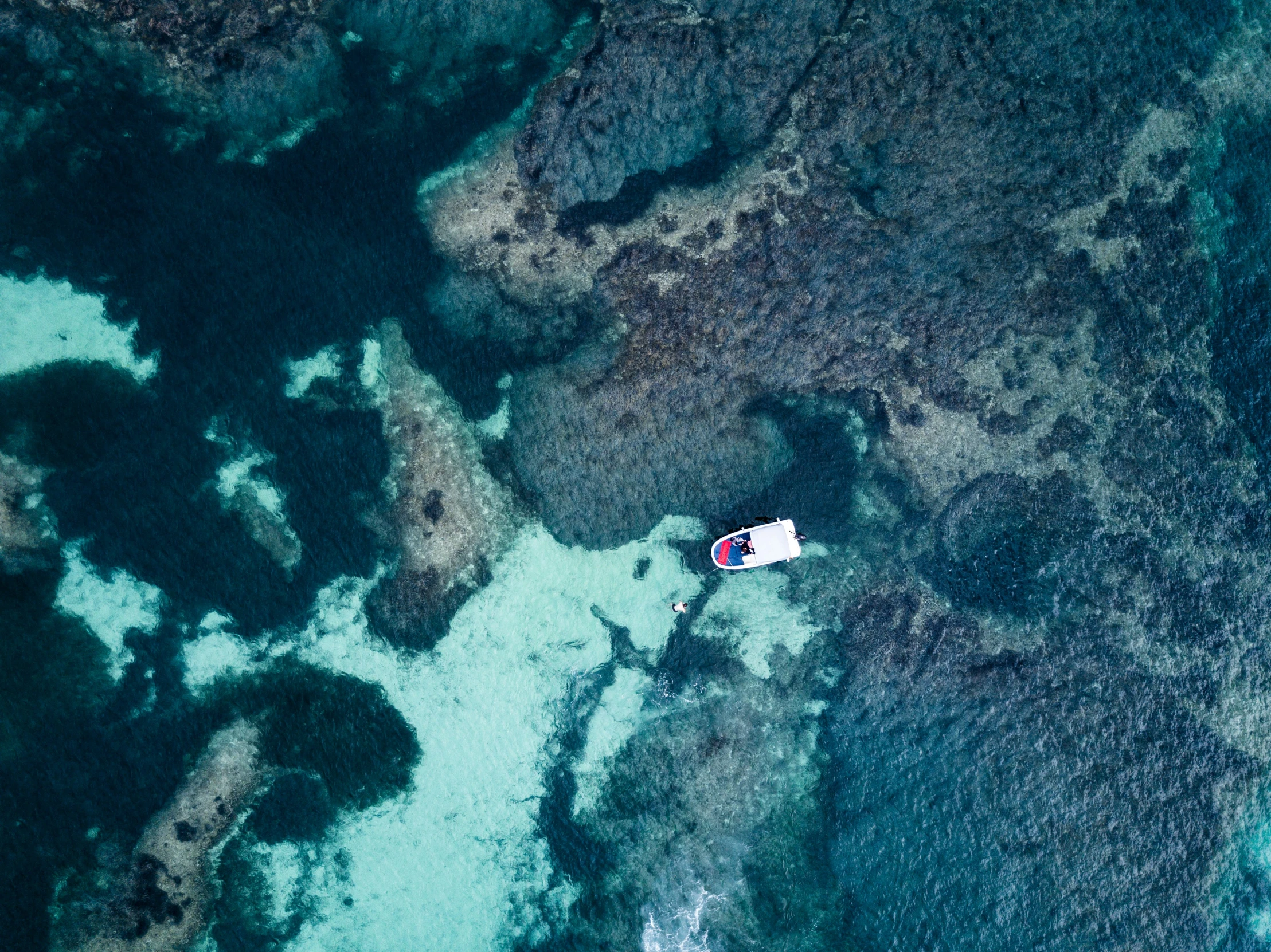 a aerial view of the ocean, with two people standing on it