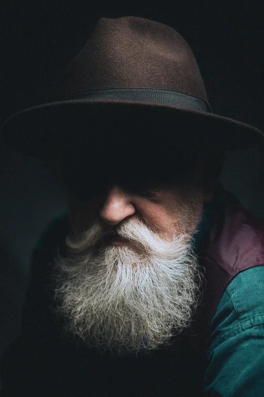 an older man with white beard wearing a hat