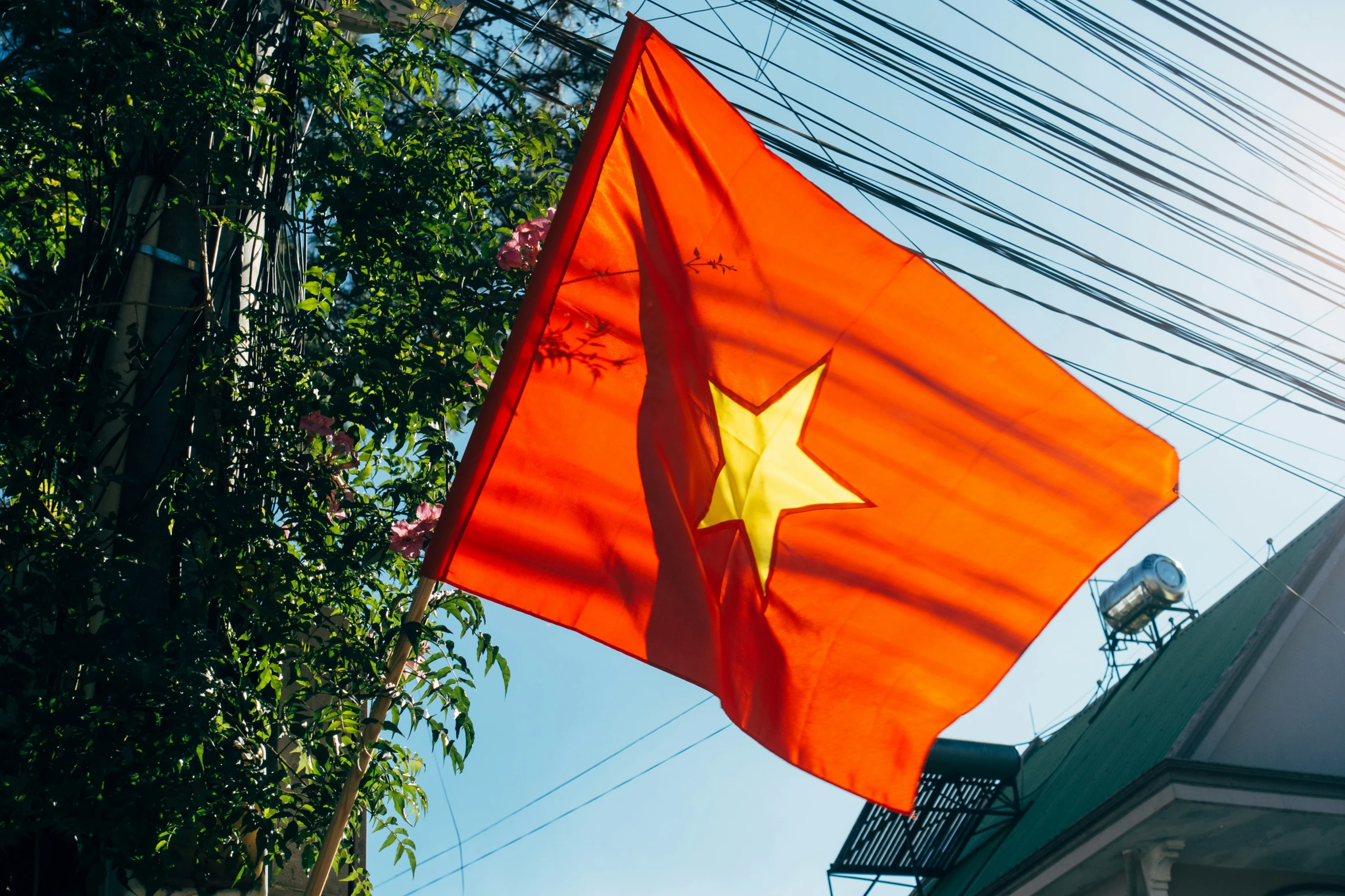 a big orange flag sitting on the side of a tall building