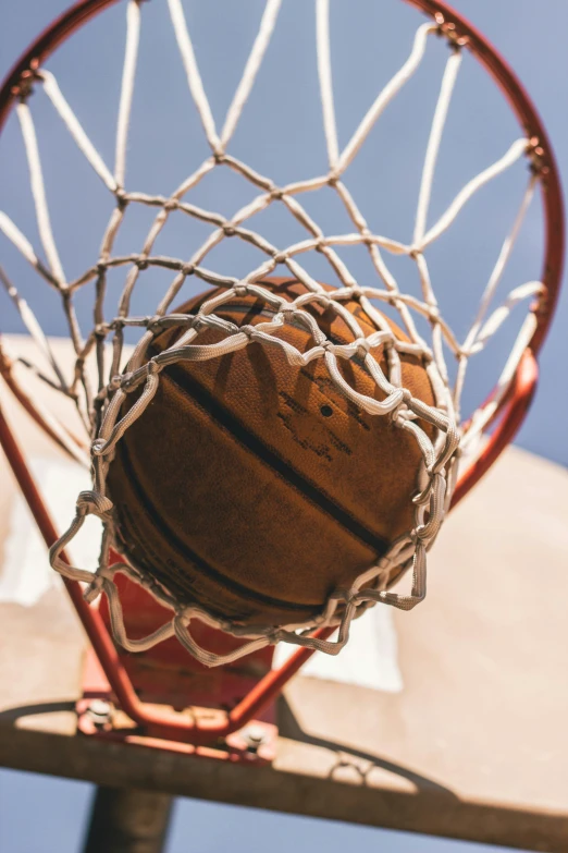 the basketball hoop is filled with an old leather ball