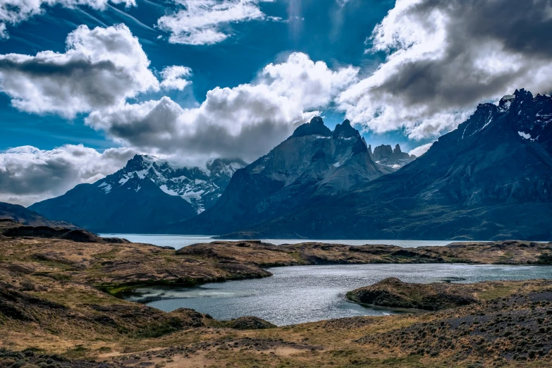 a lake and mountains on a cloudy day