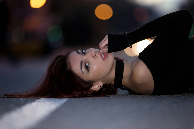 a young woman is laying down on the ground