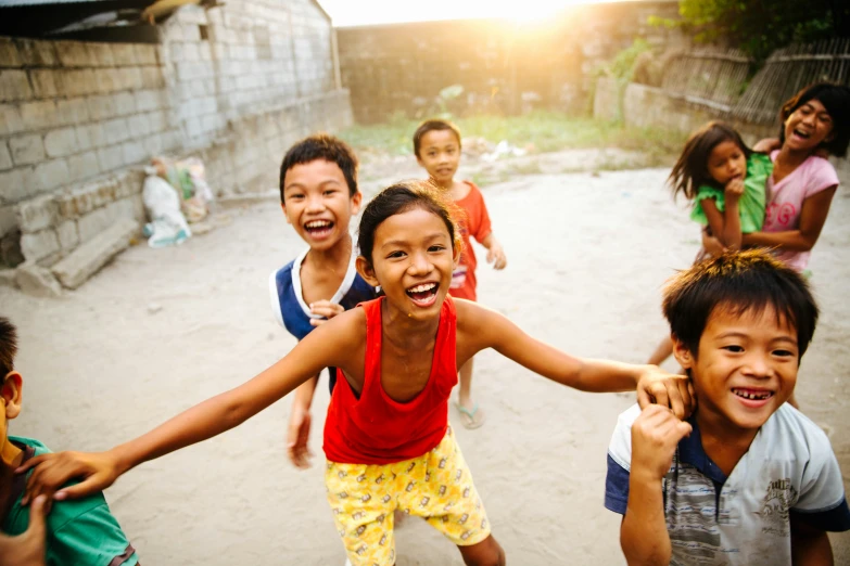 a group of small children standing around and holding hands