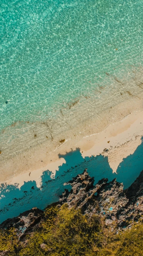 an aerial view of an ocean and sand beach