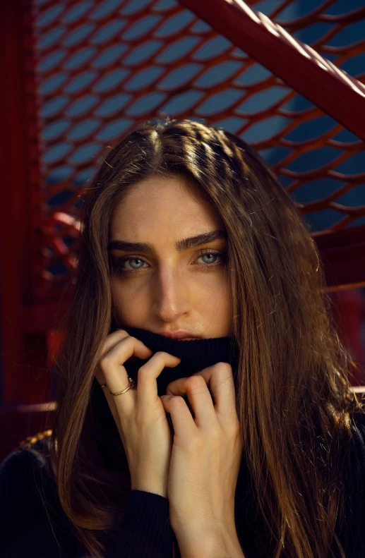 a beautiful woman is holding up a black object to her mouth