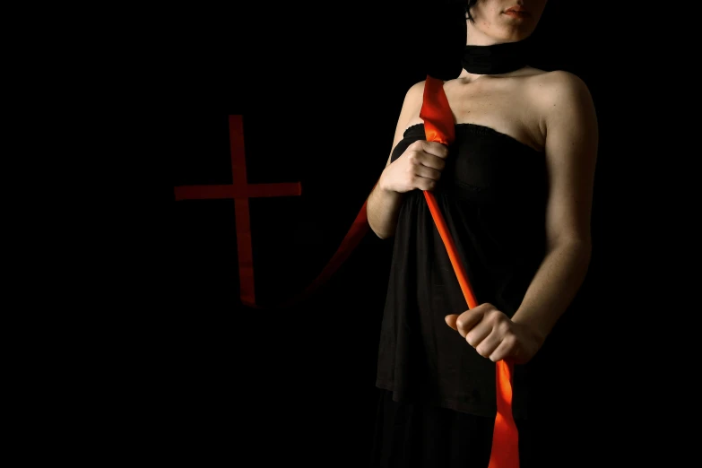 a woman in black with an orange ribbon