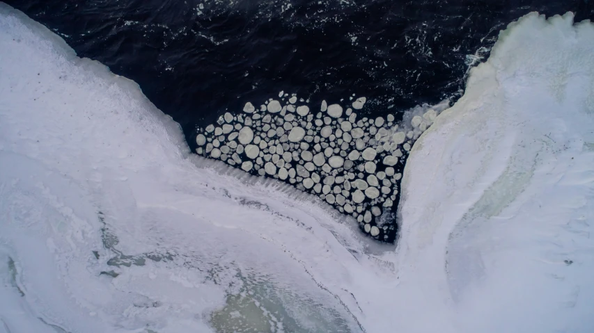 an aerial s shows icy water and large circles