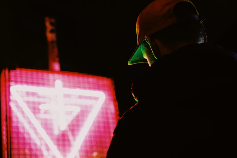 a man wearing a hat next to a red light