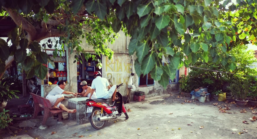 people sitting on a motorcycle in front of a shop