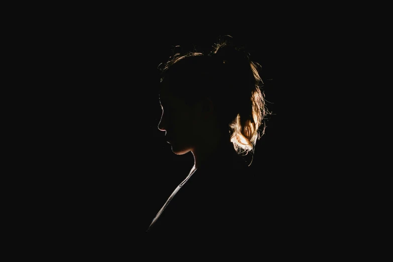 a silhouetted woman against a black background in profile