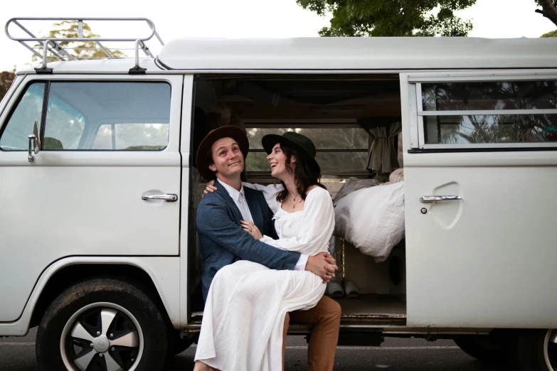 a couple in love sit inside of an old style van