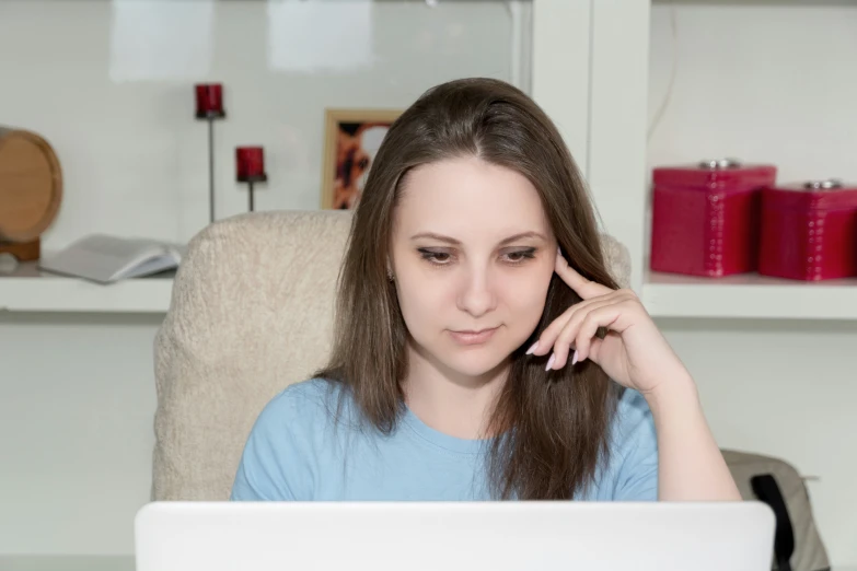 a young woman sitting in front of a laptop on a desk