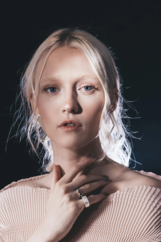 a woman is posing in a pink sweater