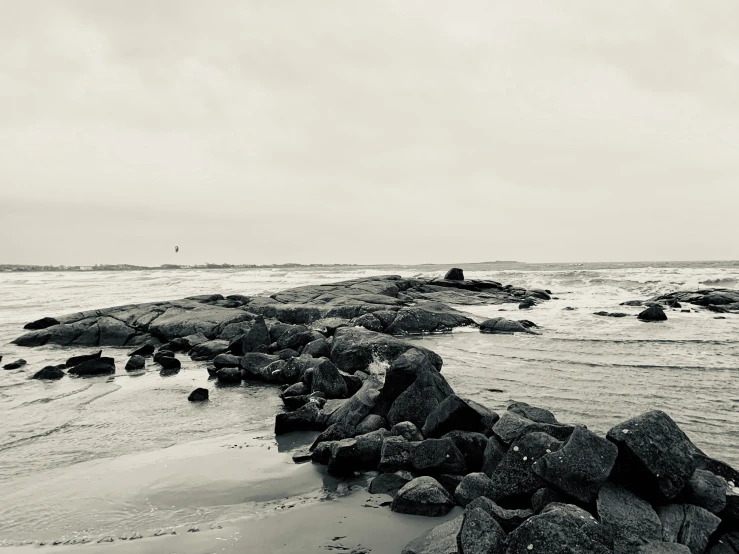 some rocks that are in the water by the beach