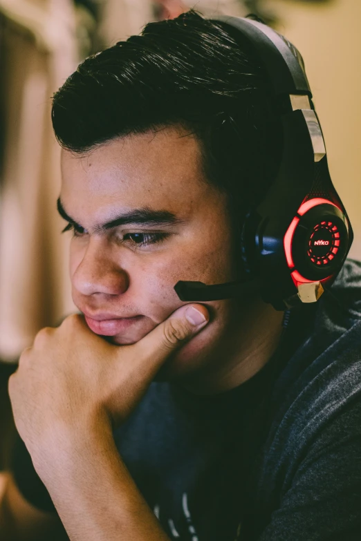 man wearing headphones with his hands under his chin