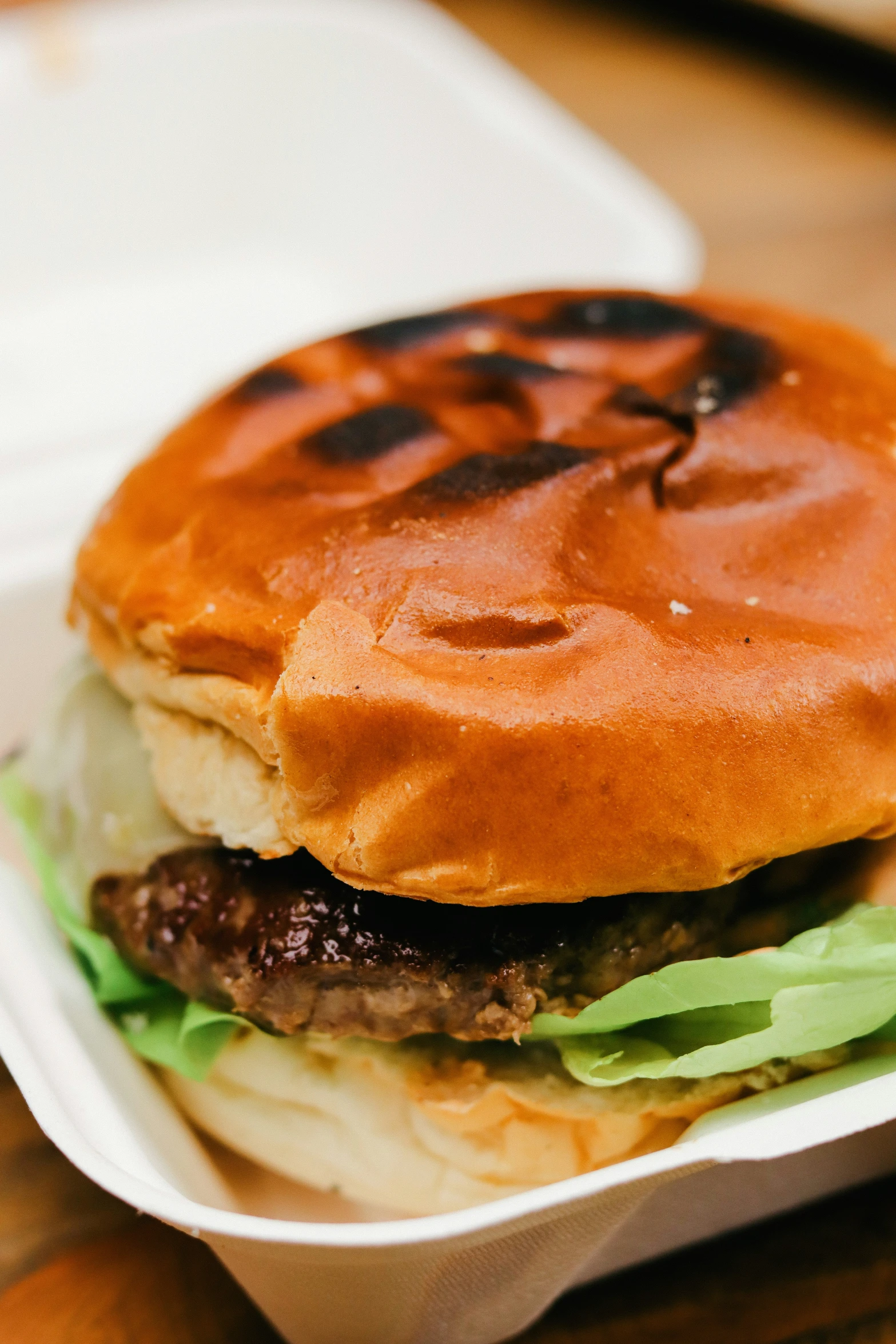 a cheeseburger with lettuce on the side in a paper tray