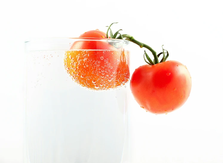 two tomato halves on top of each other in a glass