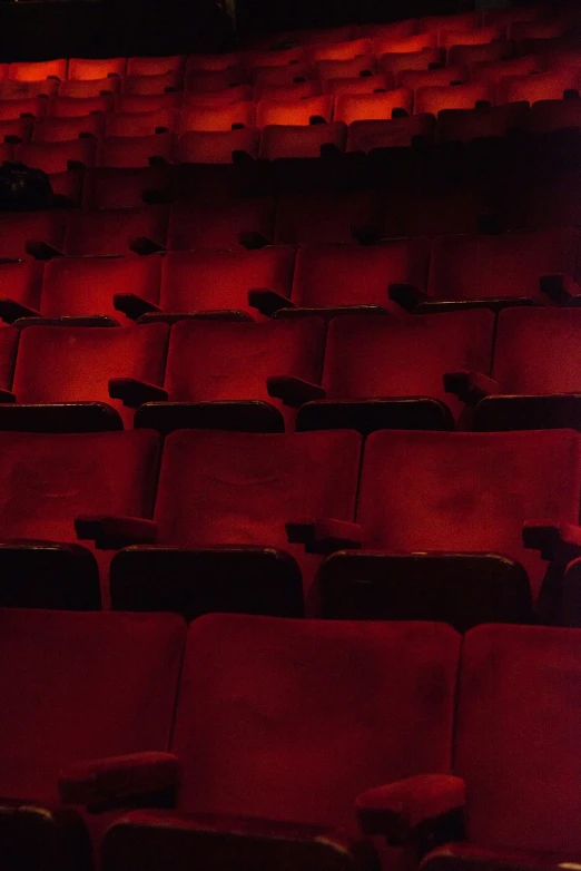 a theater with rows of empty red chairs