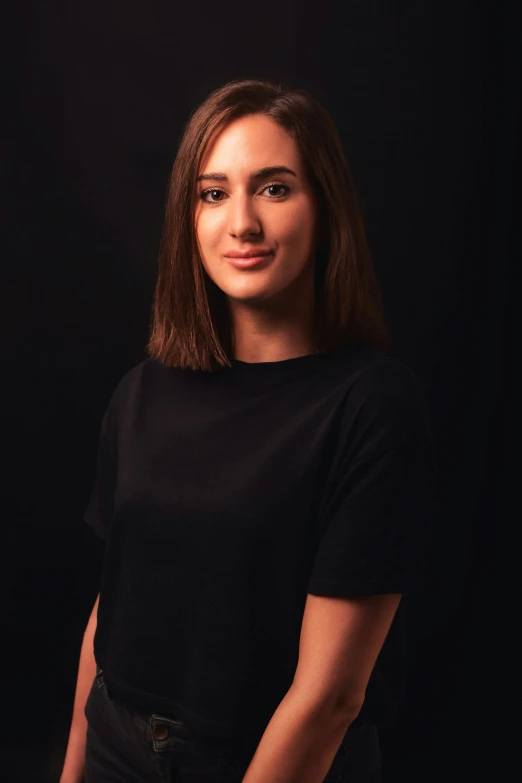 a girl posing in front of a black background