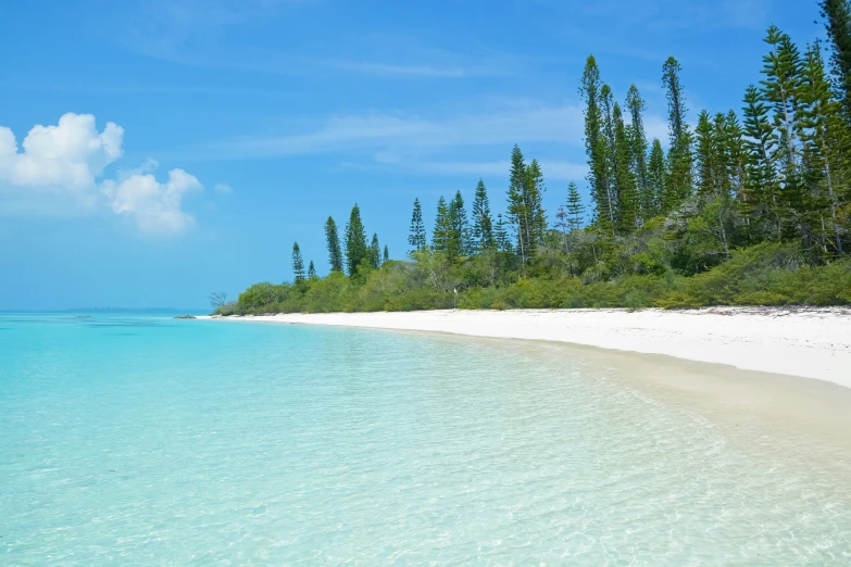 a blue water body surrounded by some white sand