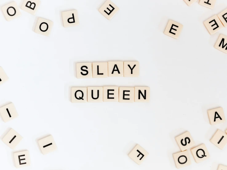 word tile with words saying slay queen on white table