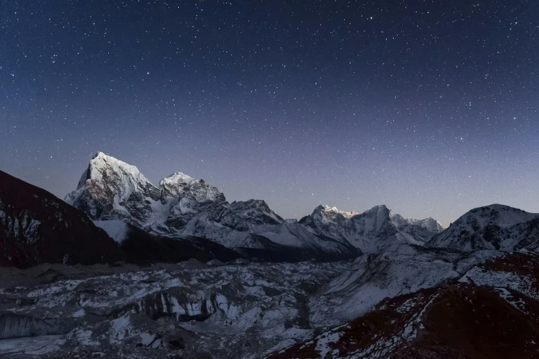 snow capped mountains in the distance with stars over them