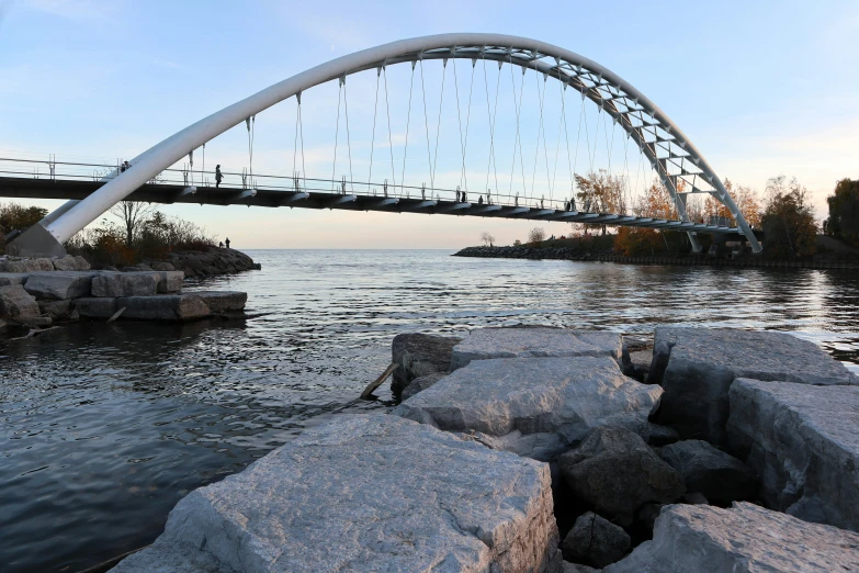 an arched bridge with the ocean and the sky in the background