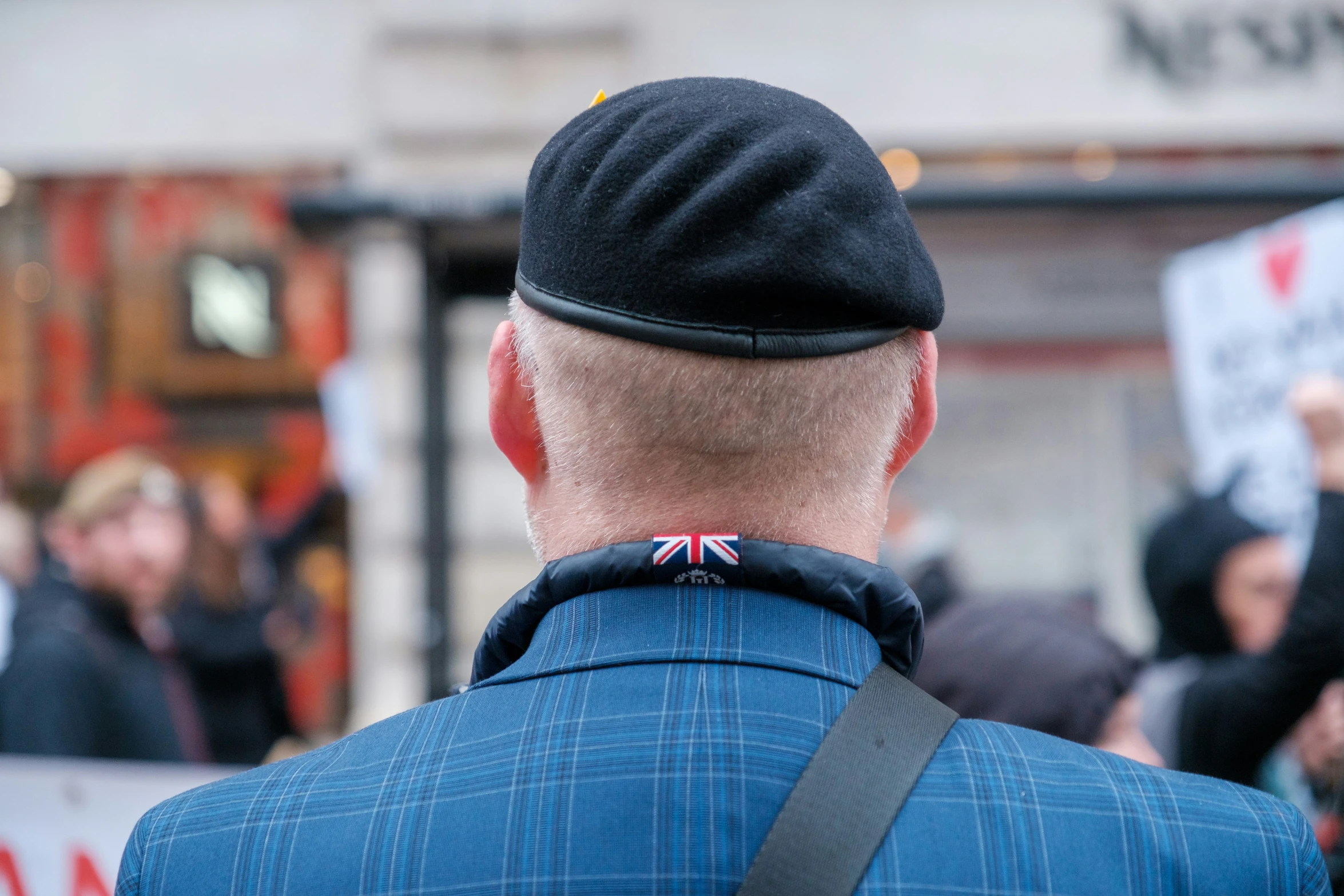 man in blue jacket and cap at the street