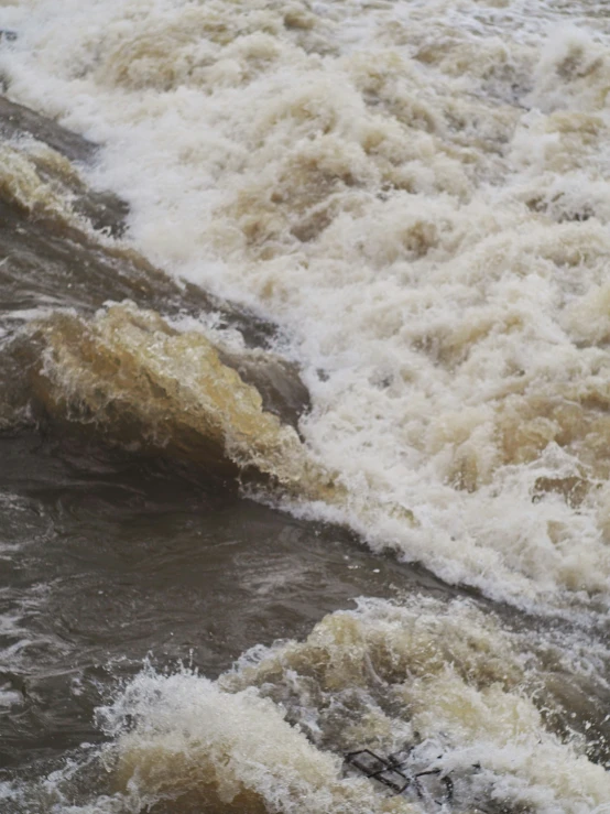 the water is rushing onto the shore next to the shore