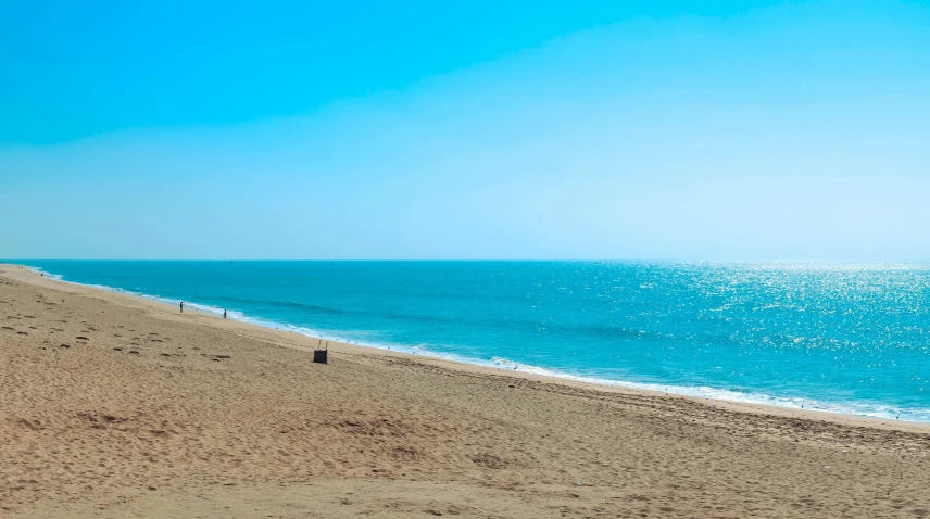 a large body of water sitting under a blue sky