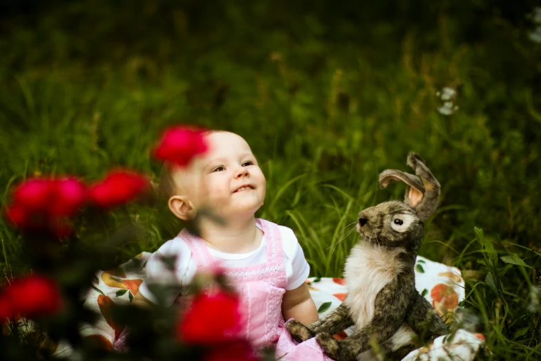 a little girl playing with a stuffed bunny