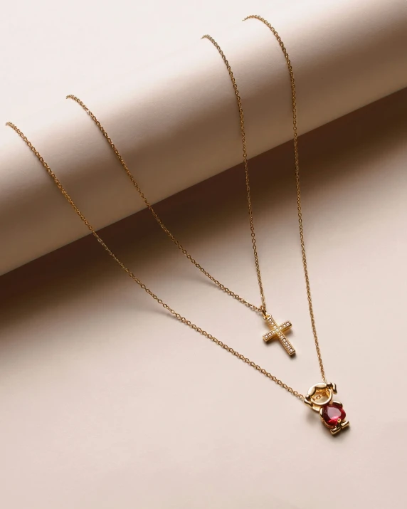 a necklace that has two cross and a heart on it