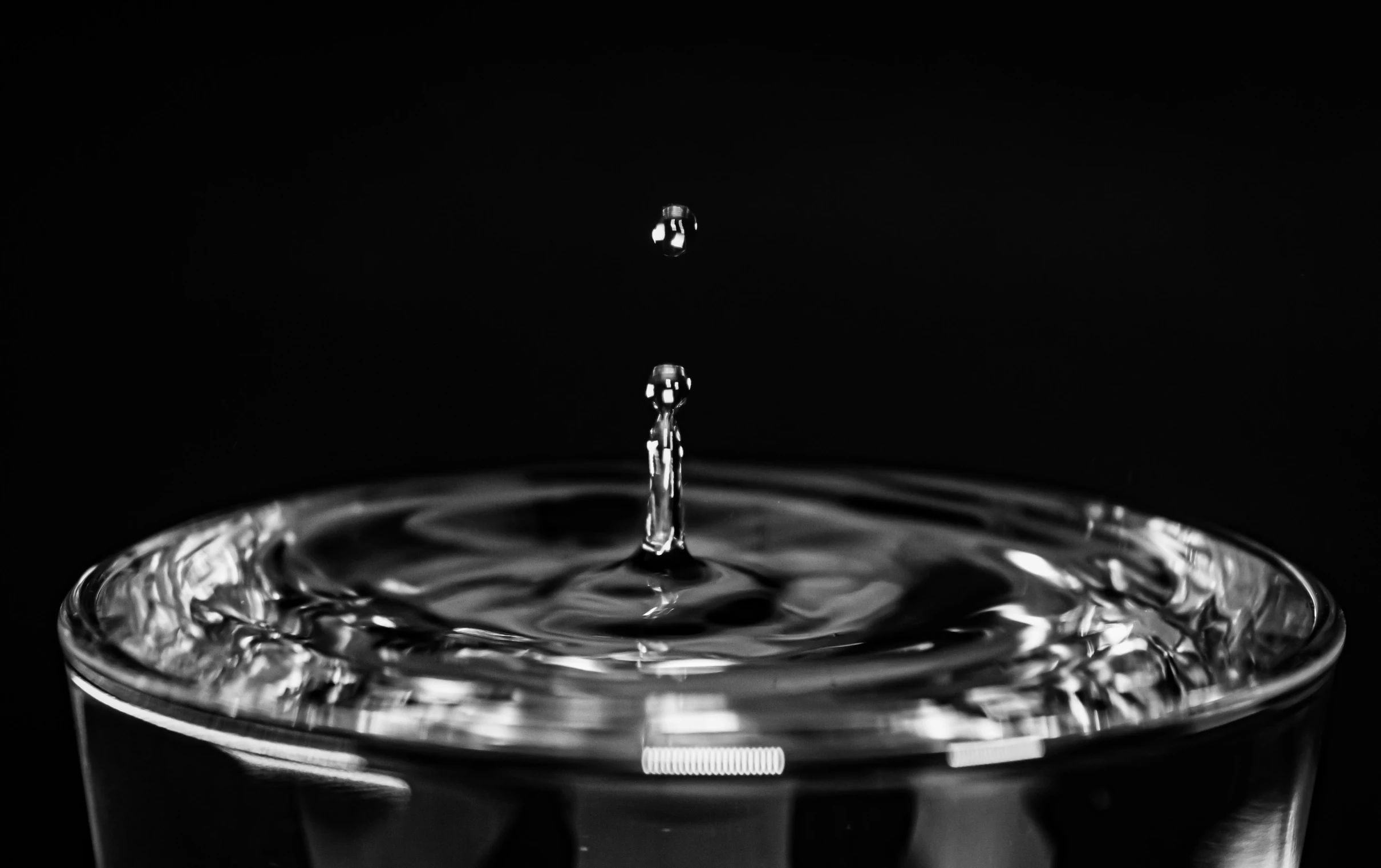 the water is splashing into the clear cup